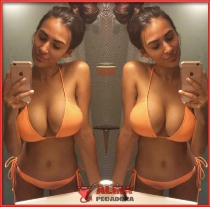 Tetona explosiva en bikini naranja haci&eacute;ndose fotos en el ba&ntilde;o