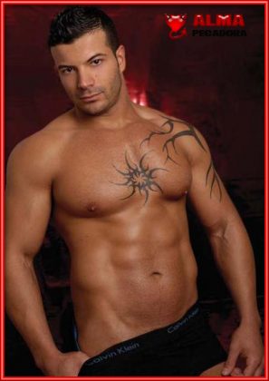 Atractivo tio cachas con tatuajes posando en gayumbos