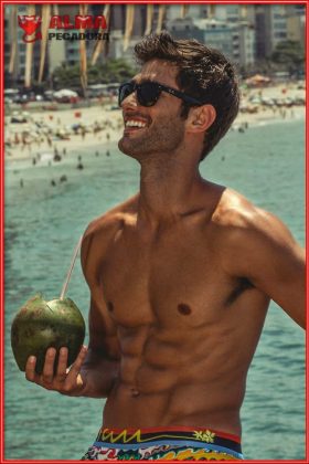 Chico guapo en la playa con unos abdominales de escándalo